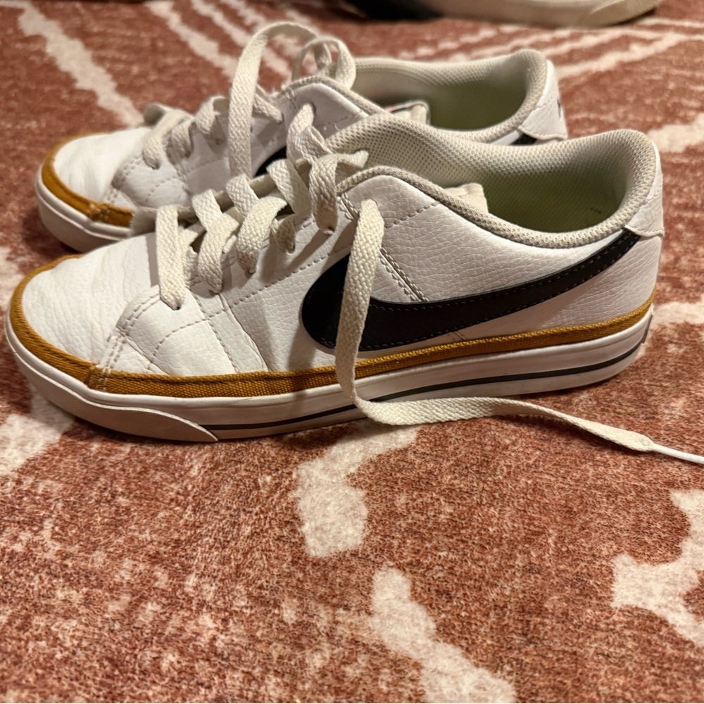 Nike White Low-Top Sneakers with Black Swoosh and Gold Trim